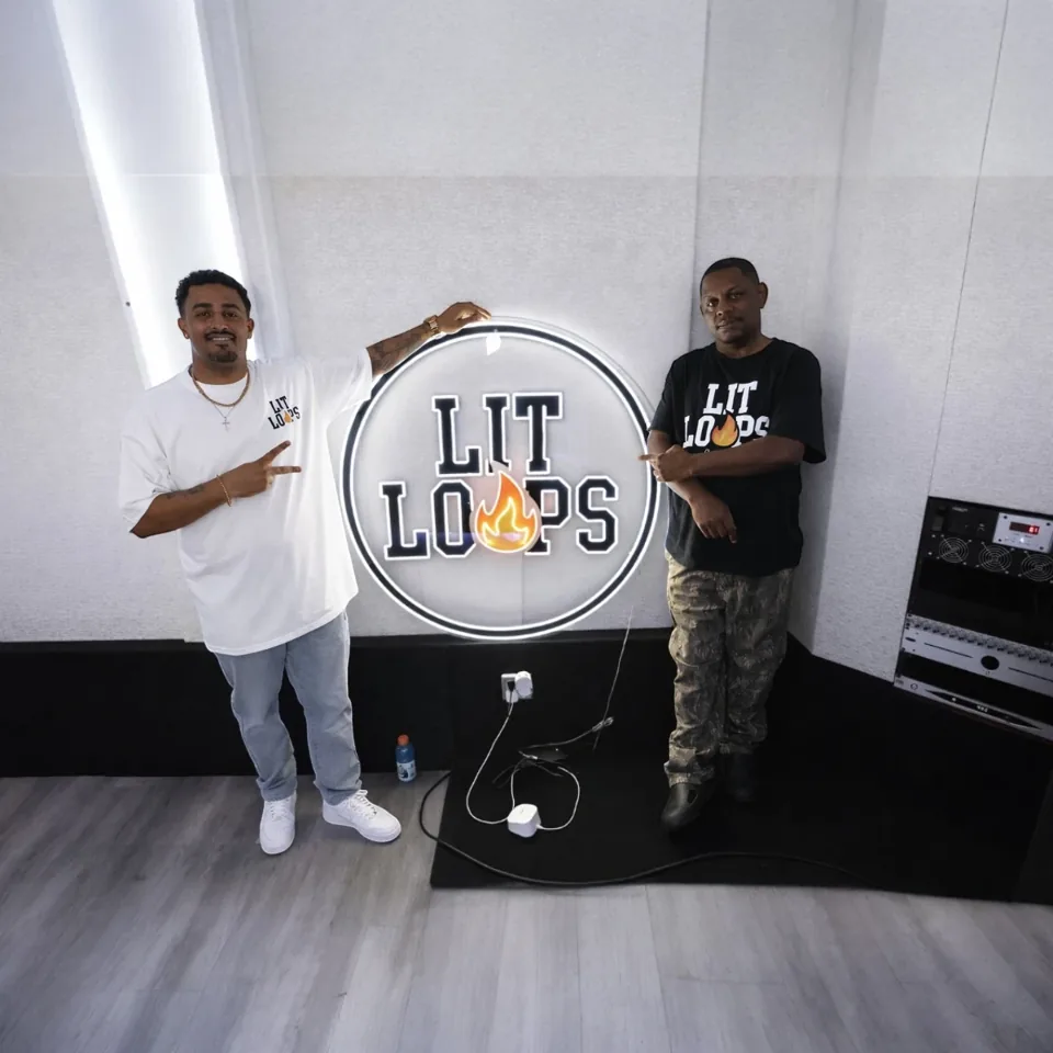 Team members beside the Lit Loops studio sign